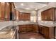 Gourmet kitchen features rich wood cabinets, granite countertops, and stainless steel appliances at 14207 W Kiowa Trl, Surprise, AZ 85374