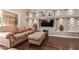 Comfortable living room includes a sofa and ottoman, stone accent wall with a large screen television at 14207 W Kiowa Trl, Surprise, AZ 85374