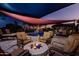 Inviting backyard with a pool, waterfall feature, and a cozy fire pit under a shaded awning at 1423 E Breezy Ct, Phoenix, AZ 85086
