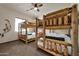 Bedroom with two sets of log frame bunkbeds, ceiling fan, and view from the window at 1423 E Breezy Ct, Phoenix, AZ 85086