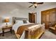 Bedroom featuring rustic wooden bedframe, ceiling fan, bedside table, and a scenic outdoor view at 1423 E Breezy Ct, Phoenix, AZ 85086