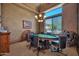Entertainment room featuring a poker table, elegant chandelier, and a large window with views of the outdoor landscaping at 1423 E Breezy Ct, Phoenix, AZ 85086
