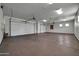 Spacious three-car garage featuring an epoxy floor and three white garage doors at 1423 E Breezy Ct, Phoenix, AZ 85086