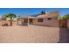 Spacious gravel backyard with privacy fence, palm tree and covered patio with seating at 14514 N 128Th Dr, El Mirage, AZ 85335