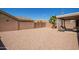Gravel backyard with privacy fence, palm tree, covered patio and exterior furniture at 14514 N 128Th Dr, El Mirage, AZ 85335