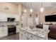 Well-designed kitchen with granite counters and modern appliances, seamlessly flowing into the living space at 14514 N 128Th Dr, El Mirage, AZ 85335