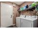 Laundry room with washer, dryer, storage shelf, and exterior access door at 14514 N 128Th Dr, El Mirage, AZ 85335