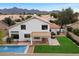 Aerial view of the backyard showcases the pool, grassy area, and covered patio with mountain views at 14862 N 90Th Pl, Scottsdale, AZ 85260