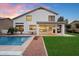 Expansive backyard with a sparkling pool, lush lawn, covered patio, and an outdoor grill at 14862 N 90Th Pl, Scottsdale, AZ 85260