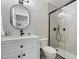 Well-lit bathroom featuring a vanity with a sink, round mirror, and glass-enclosed shower at 14862 N 90Th Pl, Scottsdale, AZ 85260
