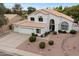 Stunning front exterior featuring a three-car garage, desert landscaping, and a charming front entrance at 14862 N 90Th Pl, Scottsdale, AZ 85260
