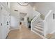 Bright foyer with a striking staircase, light wood floors, and a view into the main living space at 14862 N 90Th Pl, Scottsdale, AZ 85260