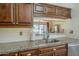 This charming kitchen has a stainless steel sink, granite countertops, and wood cabinets at 1562 E Gleneagle Dr, Chandler, AZ 85249