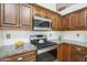 Updated kitchen features stainless steel appliances, granite countertops, and custom wood cabinetry at 1562 E Gleneagle Dr, Chandler, AZ 85249