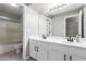 Bathroom featuring dual sinks and white cabinetry, a toilet, and a shower/bath with glass door at 15808 N 164Th Ln, Surprise, AZ 85388