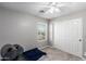 This bedroom has a large closet, a window, a ceiling fan, carpeted floors, and neutral-colored walls at 15808 N 164Th Ln, Surprise, AZ 85388