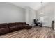 Comfortable living room featuring wood floors, vaulted ceilings, and lots of natural light with a cozy sectional couch at 15808 N 164Th Ln, Surprise, AZ 85388