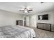 Comfortable main bedroom featuring neutral walls, ceiling fan, and carpeted floors, plus a dresser and TV at 15808 N 164Th Ln, Surprise, AZ 85388