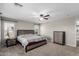 Cozy main bedroom with a large bed, dresser, and a ceiling fan with neutral colors and carpeted floors at 15808 N 164Th Ln, Surprise, AZ 85388