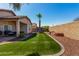 Spacious backyard features lush artificial turf, a tall palm tree, and low-maintenance desert landscaping at 17290 N 170Th Ln, Surprise, AZ 85374