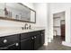 Bright bathroom featuring a black vanity, quartz countertop and a decorative framed mirror at 17290 N 170Th Ln, Surprise, AZ 85374