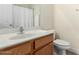 Bathroom with a white vanity, a shower with a curtain, and a toilet at 17290 N 170Th Ln, Surprise, AZ 85374