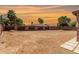 Large backyard area enclosed with block wall, string lights, and desert landscaping at sunset at 1753 E Maddison Cir, San Tan Valley, AZ 85140