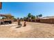 Expansive backyard with gravel and palm trees, featuring a covered patio area perfect for outdoor entertaining at 1753 E Maddison Cir, San Tan Valley, AZ 85140