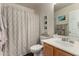 Bright bathroom featuring a shower-tub combo, wood cabinets, framed art and modern fixtures at 1753 E Maddison Cir, San Tan Valley, AZ 85140