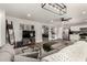 Open-concept living area with a large sofa, ceiling fan, wood floors, and a view of the kitchen at 1753 E Maddison Cir, San Tan Valley, AZ 85140