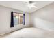 An airy bedroom featuring gray walls, plush carpet, and a window adorned with stylish blue curtains at 20419 N 34Th St, Phoenix, AZ 85050