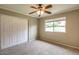 Neutral bedroom featuring a ceiling fan, window offering natural light, and closet at 2110 E Kathleen Rd, Phoenix, AZ 85022