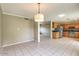 Open dining room with bright tile floors and a stylish pendant light fixture at 2110 E Kathleen Rd, Phoenix, AZ 85022