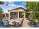 Charming backyard featuring a covered patio, paver flooring, seating, fire pit and well-manicured landscaping at 21573 N 261St Ave, Buckeye, AZ 85396