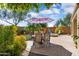 Expansive backyard with a brick-paved patio, dining set, seating area, and vibrant desert landscaping at 21573 N 261St Ave, Buckeye, AZ 85396