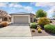 Charming single story home featuring a two car garage, desert landscaping, and a neutral color palette at 21573 N 261St Ave, Buckeye, AZ 85396