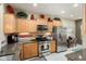 Kitchen with stainless steel appliances, granite counters, tile backsplash and light wood cabinetry at 21573 N 261St Ave, Buckeye, AZ 85396