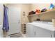 Functional laundry room with washer, dryer, shelving, and ample storage space at 21573 N 261St Ave, Buckeye, AZ 85396
