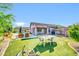 Large backyard with artificial turf, covered patio, outdoor dining, and lush landscaping at 21605 N 48Th Pl, Phoenix, AZ 85054