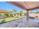 Paver patio leads to the backyard with artificial turf, landscaping, and an outdoor dining space at 21605 N 48Th Pl, Phoenix, AZ 85054