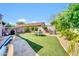 Expansive backyard featuring lush artificial turf, desert landscaping and an outdoor dining area at 21605 N 48Th Pl, Phoenix, AZ 85054