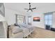 Bright primary bedroom with a ceiling fan, large windows and television at 21605 N 48Th Pl, Phoenix, AZ 85054