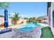 Backyard pool with travertine decking, a waterfall feature, and mature palm trees at 21605 N 48Th Pl, Phoenix, AZ 85054