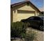 Exterior view of the house showing the garage, desert landscaping, and parked car at 2324 W Darrel Rd, Phoenix, AZ 85041