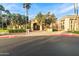 Elegant clubhouse entrance with manicured landscaping, a welcoming entrance, and palm trees in the background at 24816 S Golfview Dr # 46, Sun Lakes, AZ 85248