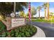 Welcoming Oakwood Country Club & Golf Course entrance with stone signage, beautiful flowers, and palm trees at 24816 S Golfview Dr # 46, Sun Lakes, AZ 85248