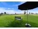 Scenic golf course view with a bench under a sun umbrella to enjoy the scenery at 24816 S Golfview Dr # 46, Sun Lakes, AZ 85248