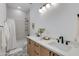 Bathroom with double sinks, modern lighting, wood cabinets and decorative patterned floors at 2927 E Osborn Rd, Phoenix, AZ 85016