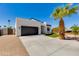 Modern home with a black garage door, desert landscaping, and a mature palm tree at 2927 E Osborn Rd, Phoenix, AZ 85016