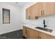 Laundry room with stainless steel sink, quartz countertop, light wood cabinets and tile flooring at 2927 E Osborn Rd, Phoenix, AZ 85016